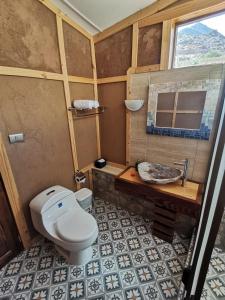 a bathroom with a toilet and a sink at Samay Lodge in Cochiguaz
