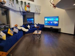 a living room with a blue couch and a tv at Beach wave in Dubai