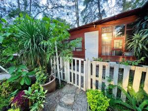 a wooden house with a fence and some plants at CABAÑAS EN ZONA 16 in Guatemala