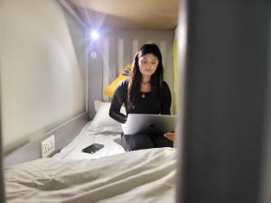 Beach wave في دبي: امرأة جالسة على سرير مع جهاز كمبيوتر محمول