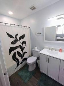 a bathroom with a shower curtain with a toilet and a sink at Mountain Foot Condo - Near Tempe and PHX Airport in Phoenix