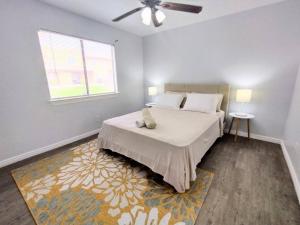 a bedroom with a bed with a ceiling fan and a window at Mountain Foot Condo - Near Tempe and PHX Airport in Phoenix