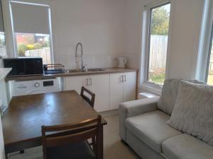 a living room with a table and a couch and a kitchen at Self contained guest suite in Oatlands