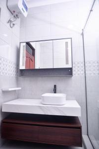 ein Badezimmer mit einem weißen Waschbecken und einem Spiegel in der Unterkunft PearlCrest townhomes in Kampala