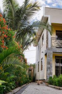 ein Gebäude mit einer Palme davor in der Unterkunft PearlCrest townhomes in Kampala