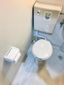 a bathroom with a toilet and a roll of toilet paper at Designer Room Japan Residence-Namba in Osaka