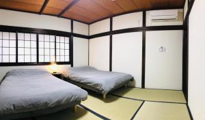 a room with two beds in a room with windows at Designer Room Japan Residence-Namba in Osaka