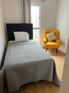 1 dormitorio con 1 cama y 1 silla amarilla en Hermoso departamento de estreno., en Lima