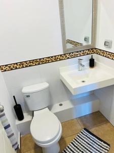 een badkamer met een wit toilet en een wastafel bij Hermoso departamento de estreno. in Lima