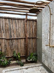 a wooden privacy fence with a tree at GUAJIRA CASA DEL MAR in Ríohacha