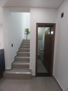 a hallway with stairs with a door and a potted plant at Sobrado da Renata no Centro de Foz in Foz do Iguaçu