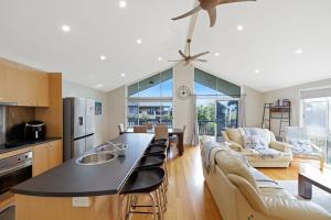 a kitchen and living room with a table and chairs at Blue Bayou in Corinella