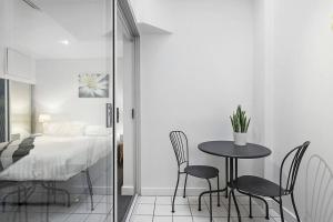 sypialnia ze stołem, krzesłami i łóżkiem w obiekcie Backpacker's Delight on Lygon Street near RMIT w Melbourne
