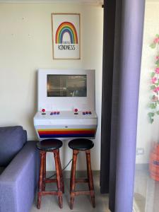 a living room with a table with a game console and two stools at Laguna del mar La Serena in La Serena