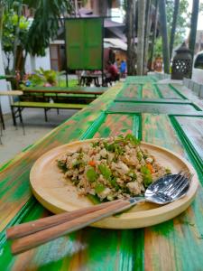un plato de comida en una mesa con tenedor y cuchara en Lotus Corner - Vegan & Plant Based B&B, en Luang Prabang