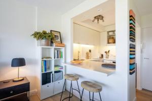 a kitchen with a counter and stools in a room at 'Aquarius Rising' Poolside in Rushcutters Bay in Sydney