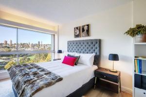 1 dormitorio con 1 cama y ventana grande en 'Aquarius Rising' Poolside in Rushcutters Bay en Sídney