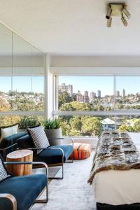 a living room with a couch and a large window at 'Aquarius Rising' Poolside in Rushcutters Bay in Sydney