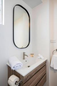 a bathroom with a sink and a mirror at 'Aquarius Rising' Poolside in Rushcutters Bay in Sydney