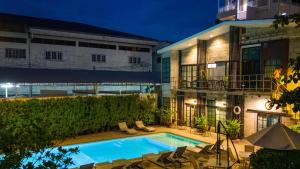 uma piscina em frente a um edifício à noite em The Warehouse Chiang Mai em Chiang Mai