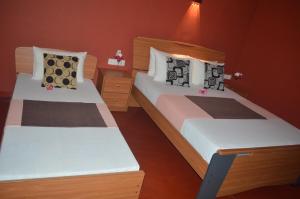 two beds in a small room with at Amazon Cabanas in Tissamaharama