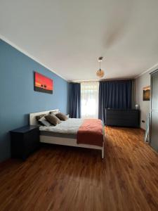 1 dormitorio con 1 cama con paredes azules y suelo de madera en Location, locaton, location! en Ulán Bator