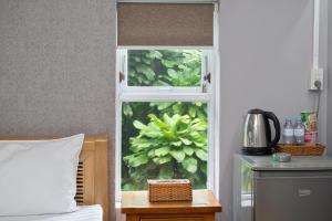 una habitación con una ventana con una planta en Lilac Cottage Homestay, en Phu Quoc