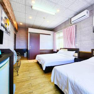 a hotel room with two beds and a tv at Gajilia B&B in Chenggong