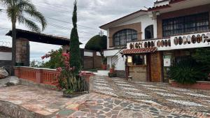 a large house with a palm tree and a building at Hotel Colonial Taxco in Taxco de Alarcón