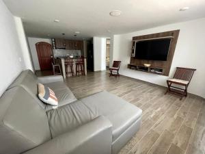 a living room with a couch and a flat screen tv at Lugar perfecto para ti a solo 300 metros de la playa in Gaira