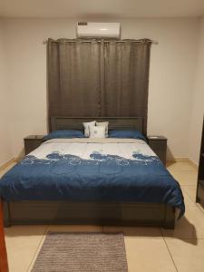 a bedroom with a bed with a blue comforter at A&N appartementen in Lelydorp