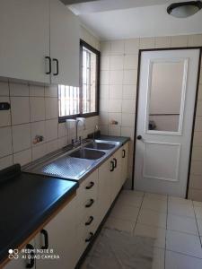 eine Küche mit einem Waschbecken, einem Fenster und einer Tür in der Unterkunft Depto en el centro de Ovalle in Ovalle