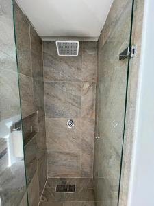 a shower with a glass door in a bathroom at Lugar perfecto para ti a solo 300 metros de la playa in Gaira