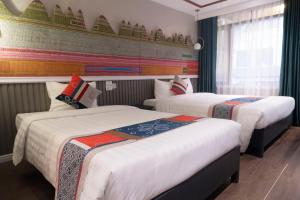 una habitación de hotel con 2 camas en una habitación en Swan Sapa Hotel, en Sa Pa