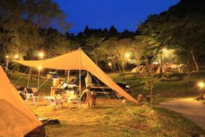 a tent is set up in a field at night at ぼっちの森 in Minamiizu