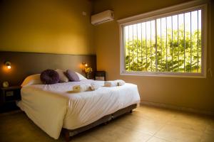 1 dormitorio con 1 cama grande y ventana en Departamento Candelaria en Maipú