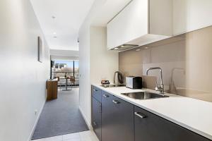 a kitchen with a sink and a counter top at Seasons Heritage Melbourne in Melbourne