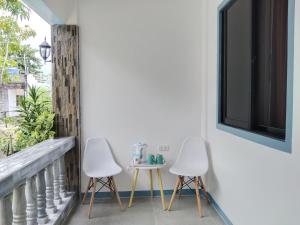 dwa krzesła i stół na balkonie z oknem w obiekcie ELEN INN - Malapascua Island Air-conditioned Room2 w mieście Wyspa Malapascua