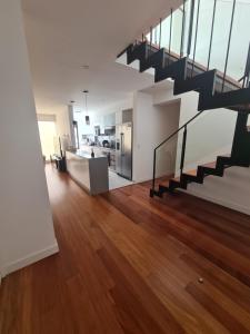 sala de estar de planta abierta con escalera y suelo de madera en Miraflores habitación separada con privacidad dentro de departamento compartido en Lima