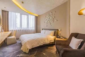 um quarto de hotel com uma cama e um sofá em Beijing Qianyuan Hotel em Pequim