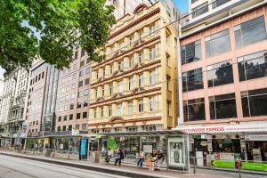 uma rua da cidade com pessoas andando em frente a um prédio em Flinders Escape - Explore the Best of Melbourne em Melbourne