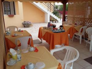 a patio with two tables and white chairs at Kamarina Land in Santa Croce Camerina