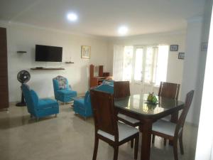 sala de estar con mesa de comedor y sillas azules en Apartamento duplex Buganaviles, en Neiva