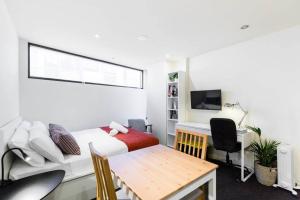 Schlafzimmer mit einem Bett und einem Schreibtisch mit einem Computer in der Unterkunft Simple on Swanston - A Central Student Accom Studio in Melbourne