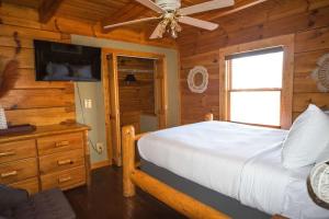 Schlafzimmer mit einem Bett und einem Deckenventilator in der Unterkunft Sugar Tree Cabin in Pigeon Forge