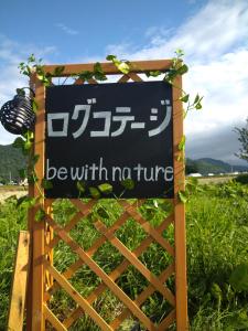 a sign that says be with nature on a fence at Log Cottage be with nature in Furano