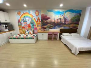 Habitación con 2 camas y una pintura en la pared. en Disney Suite II@Champs Elysees, en Kampar
