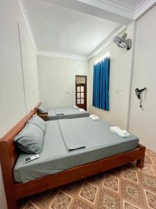un letto in una camera con tenda blu di Trust House ( Hostel and Motobike Rental ) a Bản Tùy