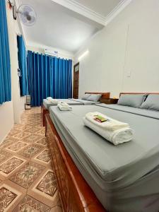 una camera da letto con due letti con asciugamani sopra di Trust House ( Hostel and Motobike Rental ) a Bản Tùy