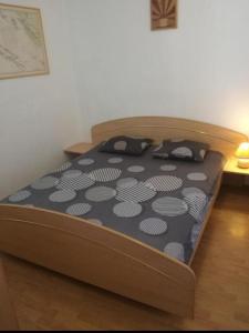 ein Bett mit einer schwarzen und weißen Bettdecke in einem Schlafzimmer in der Unterkunft Apartment Kova - 10 m from sea in Murter
